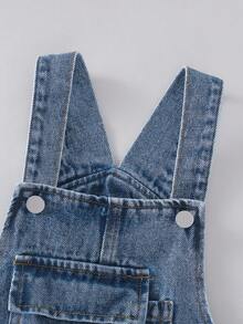 年轻女孩复古中蓝色水洗牛仔背带裤，蝴蝶结装饰，宽松直筒版型，面料柔软舒适，休闲百搭，女孩牛仔裤