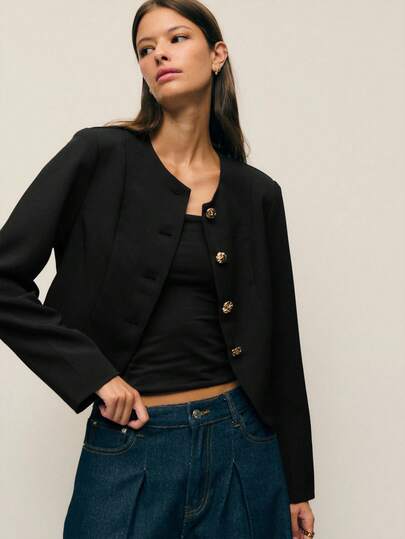 Nöista 这款女式西装外套采用短款剪裁，凸显腰线。圆领设计柔化了职业装的优雅气质，更添一丝柔美。四颗金色压纹纽扣点缀在前襟中央，既增添装饰感，又不失精致优雅。