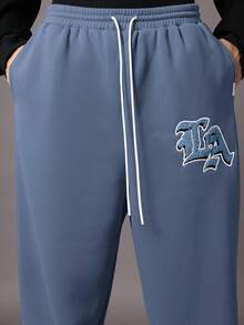 SUMWON 复古风经典低裆慢跑运动裤，饰有 LA 标志贴片和抽绳腰带，适合休闲街头风秋冬系列。 - 霧霾藍 - 查看 6