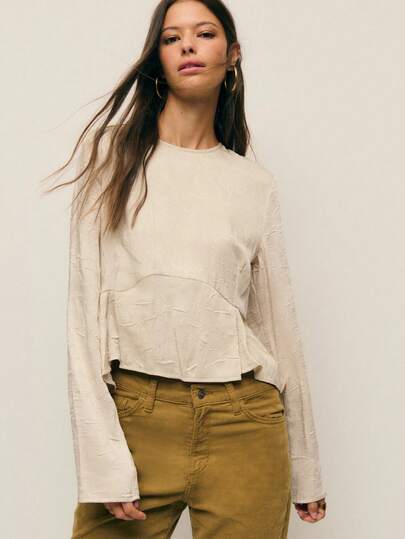 Nöista Esta blusa de manga larga en un tejido especial con textura es perfecta para el otoño. Satisface tus necesidades de calor diario a principios del otoño, con líneas limpias y elegantes. La silueta general es ajustada, con una cintura ceñida que acentúa tus proporciones. El bajo delantero tiene una construcción con forma personalizada para una mayor dimensión y forma. El color general es sutil, creando un aspecto minimalista y listo para el transporte perfecto para la mujer urbana.