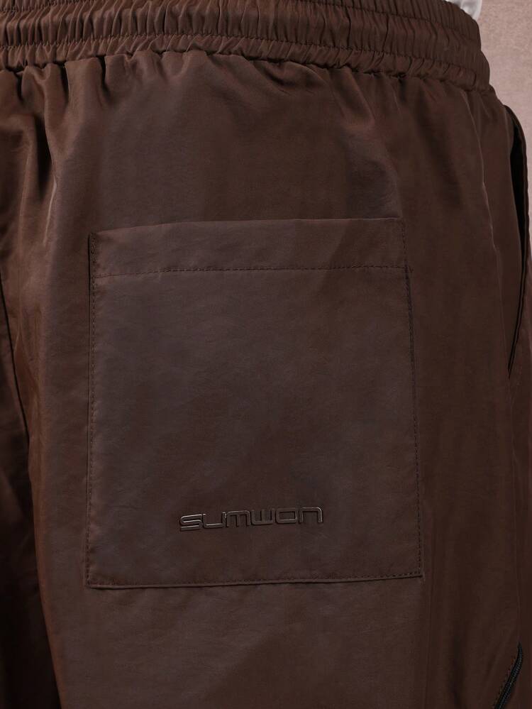 대비되는 파이핑과 신축성 있는 허리가 특징인 와이드 레그 나일론 팬츠