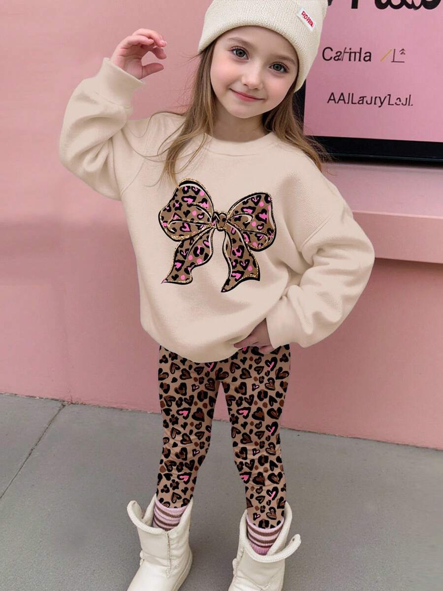 SHEIN Bộ đồ Happikins 2 món cho bé gái, gồm áo nỉ dài tay cổ tròn dáng rộng thoải mái và quần legging, màu kem Ireland, họa tiết da báo ngọt ngào với nơ lấp lánh, thích hợp cho mùa thu đông. - Nhiều màu - Xem 1