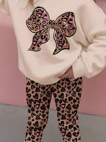 SHEIN Bộ đồ Happikins 2 món cho bé gái, gồm áo nỉ dài tay cổ tròn dáng rộng thoải mái và quần legging, màu kem Ireland, họa tiết da báo ngọt ngào với nơ lấp lánh, thích hợp cho mùa thu đông. - Nhiều màu - Xem 4