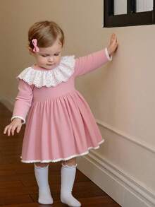 SHEIN 女宝宝纯色圆领荷叶边下摆长袖A字裙。荷叶边圆领设计，优雅大方。荷叶边长袖A字廓形，时尚动感。无论是玩耍还是参加家庭聚会，宝宝都能成为最闪耀的存在。 - 粉色 - 查看 1