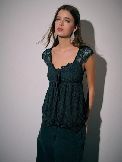 Nöista 精致的蕾丝纹理和短袖是这款黑色紧身胸衣式衬衫的特色。这款优雅的女式衬衫采用褶皱紧身胸衣，胸部配有精致的领带，为经典休闲上衣增添了浪漫气息。