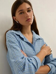 Áo sơ mi kẻ sọc xanh thoải mái của Nöista cài nút phía trước với cổ áo xòe cổ điển, tay dài có vạt cuộn và gấu áo hơi ngắn - mang đến kiểu dáng thoải mái nhưng vẫn lịch sự, lý tưởng cho phong cách thường ngày, đi chơi và công sở. - Màu xanh lam - Xem 5