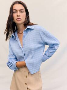 Áo sơ mi kẻ sọc xanh thoải mái của Nöista cài nút phía trước với cổ áo xòe cổ điển, tay dài có vạt cuộn và gấu áo hơi ngắn - mang đến kiểu dáng thoải mái nhưng vẫn lịch sự, lý tưởng cho phong cách thường ngày, đi chơi và công sở. - Màu xanh lam - Xem 1