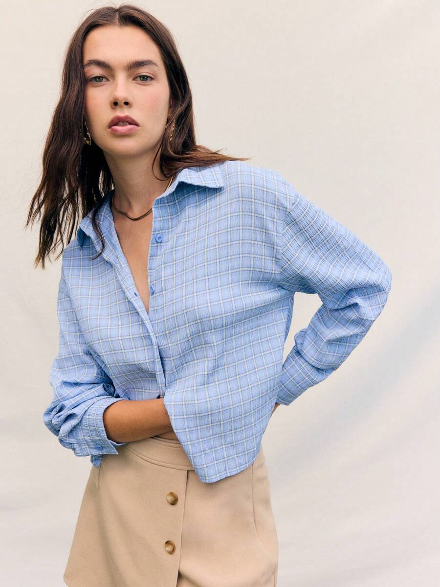 Áo sơ mi kẻ sọc xanh thoải mái của Nöista cài nút phía trước với cổ áo xòe cổ điển, tay dài có vạt cuộn và gấu áo hơi ngắn - mang đến kiểu dáng thoải mái nhưng vẫn lịch sự, lý tưởng cho phong cách thường ngày, đi chơi và công sở. - Màu xanh lam - Xem 1