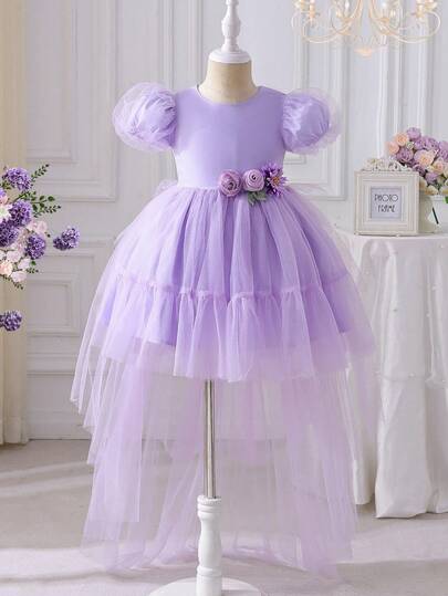 女孩身穿紫色飘逸长裙，作为正式晚礼服。裙子上点缀着小花朵图案，适合生日派对或正式宴会。既美丽又可爱。