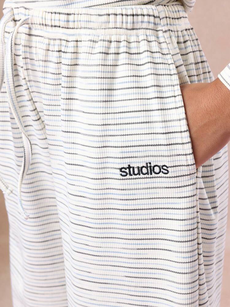 Completo composto da top corto in maglia a coste a righe e pantaloni a gamba larga