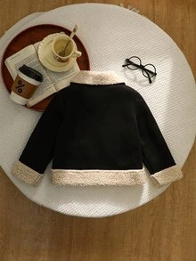 年轻女孩黑色仿麂皮羊毛复合夹克，采用柔软的麂皮羊毛复合纹理，衣领、下摆和袖口处饰有奶油色羊毛饰边，银色拉链开合，对称仿口袋，圆形纽扣装饰，剪裁剪裁融合了复古与时尚风格，秋冬