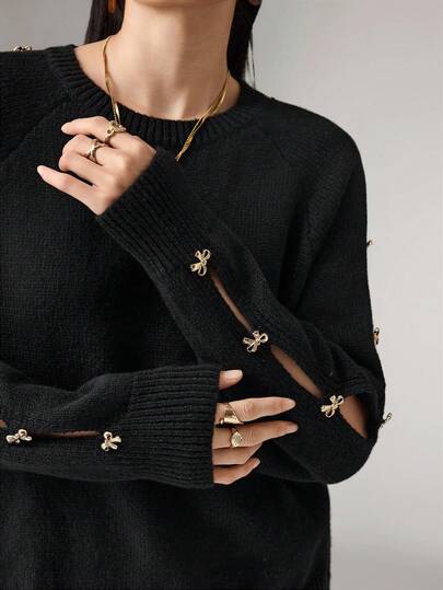 Heiryn Damtröja med rund hals och raglanärm, moderiktig tröja med metallrosettdekor, höst/vinter, svart topp, svart stickad tröja, damtröjor, guldfärgad rosetttröja