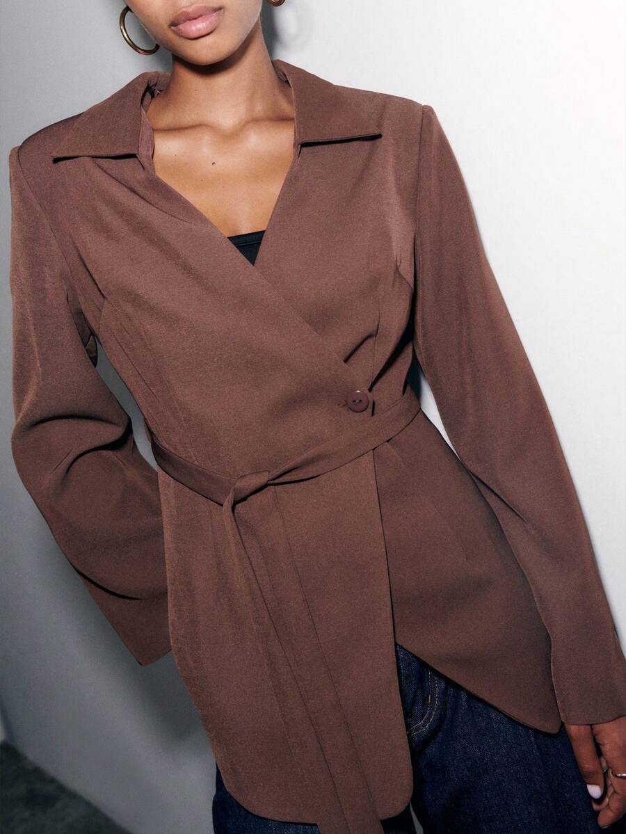 Nöista Elegant And Versatile, This Brown Jacket Features A Wrap Design With A Self-Tie Belt That Flatters The Waist. The Tailored Fit And Lapel Collar Give It A Polished Look, Perfect For Work Or Evening Wear. A Chic Brown Blazer For Women That Adds Sophistication To Any Outfit.
