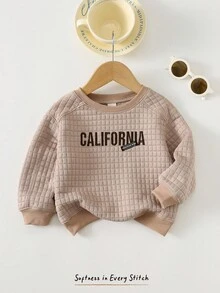 Cozy Pixies Klassischer Babypullover mit Karomuster, Jacquard-Stoff, gesticktem Buchstabenmotiv, Rundhalsausschnitt und langen Ärmeln – ideal für Jungen und Mädchen. Perfekt für Herbst und Winter. Auch als Babypullover Einfarbig erhältlich. Unisex-Kleidung. - Aprikosenfarben - Übersicht 1