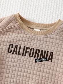 Cozy Pixies Klassischer Babypullover mit Karomuster, Jacquard-Stoff, gesticktem Buchstabenmotiv, Rundhalsausschnitt und langen Ärmeln – ideal für Jungen und Mädchen. Perfekt für Herbst und Winter. Auch als Babypullover Einfarbig erhältlich. Unisex-Kleidung. - Aprikosenfarben - Übersicht 4
