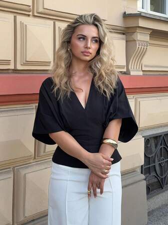 Jeta Ari Elegant enfärgad, lös passform, kortärmad, svart blus, minimalistisk design med rosett i ryggen, mångsidig aprikosfärgad topp för kontor/avslappnad användning