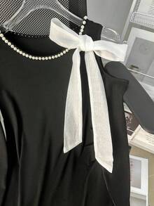 GlowEve Elegantes Damen T-Shirt mit schwarzer Perlenkette, weißer Schleife und offenem Schulterbereich - Schwarz und Weiss - Übersicht 4