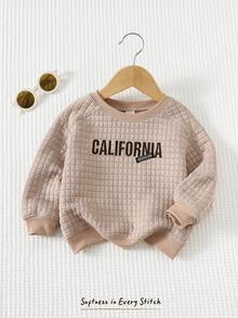 Cozy Pixies Klassischer Babypullover mit Karomuster, Jacquard-Stoff, gesticktem Buchstabenmotiv, Rundhalsausschnitt und langen Ärmeln – ideal für Jungen und Mädchen. Perfekt für Herbst und Winter. Auch als Babypullover Einfarbig erhältlich. Unisex-Kleidung. - Aprikosenfarben - Übersicht 3