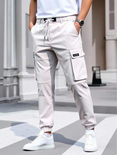 Manfinity Homme بنطلون جوجر كاجوال بجيوب حمولة وخصر بسحاب رسومات حرفية للرجال، بنطلون حمولة أبيض، ملابس الشارع، خريف