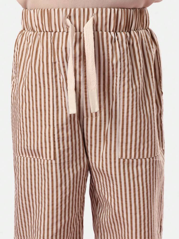 レトロなオレンジソーダのスウェットシャツとストライプパンツ