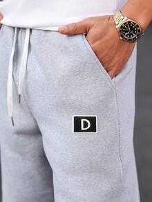 Manfinity Homme Calça de moletom masculina cinza com bordado de letras, cordão na cintura, bolso e modelagem solta. Ideal para academia, clubes e atividades físicas.
