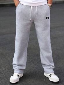 Manfinity Homme Calça de moletom masculina cinza com bordado de letras, cordão na cintura, bolso e modelagem solta. Ideal para academia, clubes e atividades físicas.