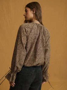 Nöista 这款灰褐色和黑色动物纹印花衬衫采用飘逸的廓形、系带领口和荷叶边前襟设计，非常适合大胆的秋季造型、俏皮的冬季叠穿，或现代女性的休闲装扮。 - 棕色 - 查看 6