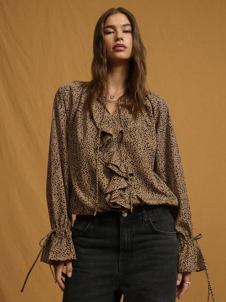 Nöista 这款灰褐色和黑色动物纹印花衬衫采用飘逸的廓形、系带领口和荷叶边前襟设计，非常适合大胆的秋季造型、俏皮的冬季叠穿，或现代女性的休闲装扮。 - 棕色 - 查看 1