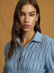 Nöista 精致的褶饰纽扣衬衫，采用轻盈的褶皱棉布制成，上身采用褶皱设计，下摆饰有精致的荷叶边，泡泡袖收拢，形成褶饰喇叭袖口和柔软的尖领。透气面料带来透气舒适感和微妙的弹性，塑造纤细腰身、柔美廓形，是春季造型的完美之选，也是秋季轻松过渡的叠穿之选。 - 藍色 - 查看 4