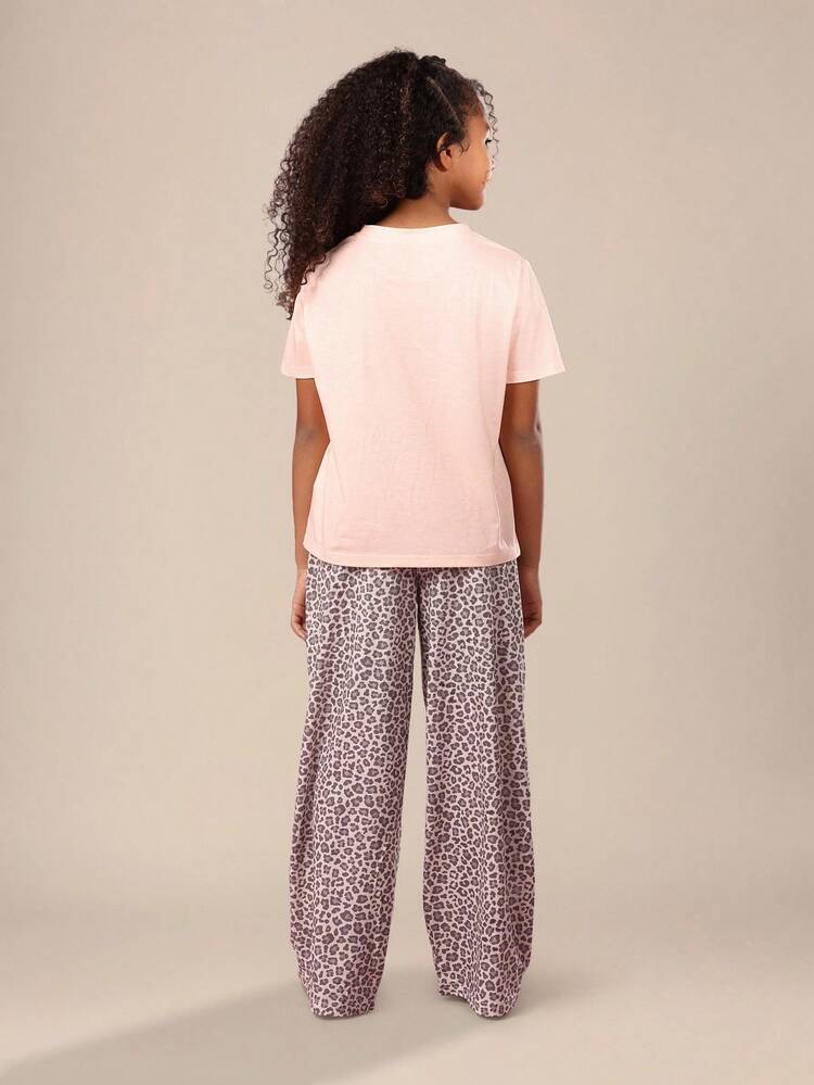 かわいいクマのプリントが入ったピンクのTシャツとヒョウ柄パンツ