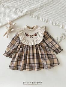 Cozy Pixies Vestido a cuadros de manga larga con cuello redondo, volantes en el bajo, cintura con lazo y bordado floral en contraste de color para niña bebé