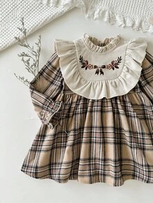 Cozy Pixies Vestido a cuadros de manga larga con cuello redondo, volantes en el bajo, cintura con lazo y bordado floral en contraste de color para niña bebé