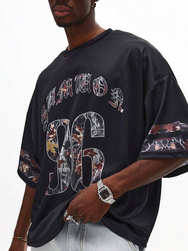 T-shirt oversize con lettere gotiche e numeri mimetici