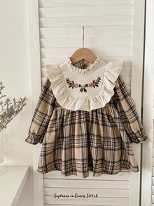 Cozy Pixies Vestido a cuadros de manga larga con cuello redondo, volantes en el bajo, cintura con lazo y bordado floral en contraste de color para niña bebé