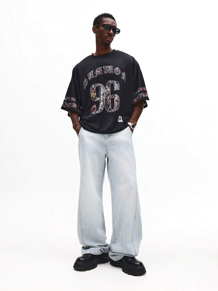 T-shirt oversize con lettere gotiche e numeri mimetici