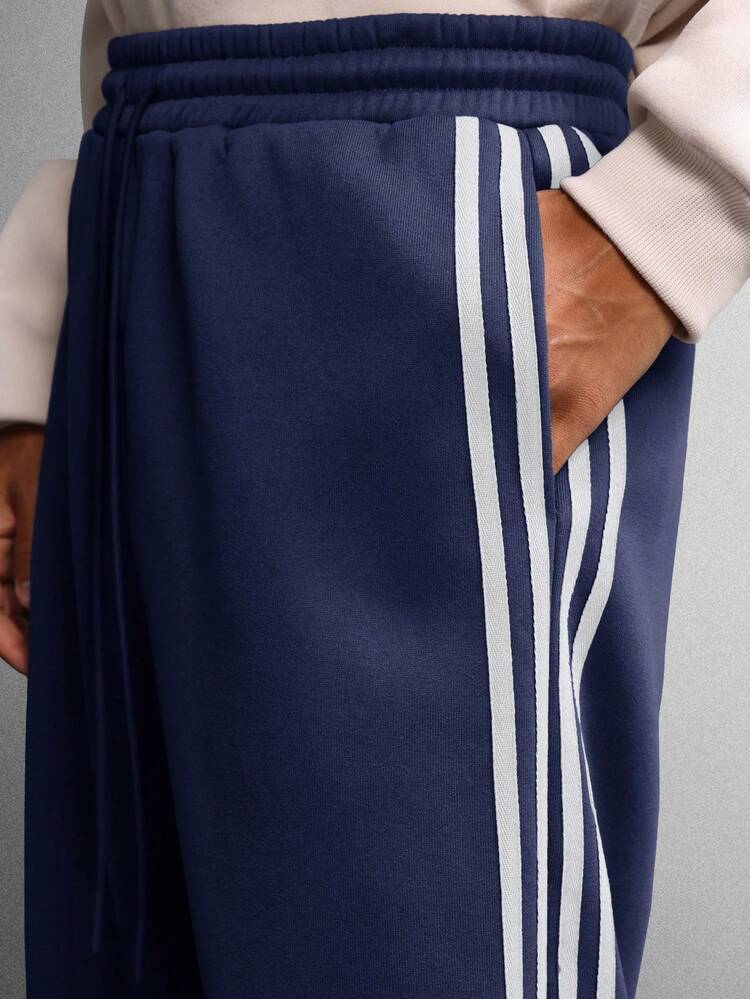 Calças de treino de perna larga com listras laterais