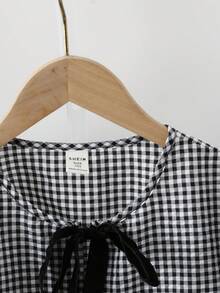 SHEIN Áo sơ mi nữ tuổi teen kiểu dáng tối giản, thoải mái, cổ tròn, tay dài, có nơ, chất liệu vải dệt họa tiết, thích hợp cho mùa tựu trường, mùa đông thu, các lễ hội, Halloween, Giáng sinh, Năm mới, quà tặng Giáng sinh. Tuyệt vời cho mặc thường ngày và đi học vào mùa thu đông. Áo thoải mái dễ mặc, phong cách ấm áp mùa thu đông, phù hợp cho mặc hàng ngày mùa thu/đông, phong cách đường phố, mặc ở nhà. Áo sơ mi nữ tay dài có nơ, họa tiết kẻ caro. - Đen và trắng - Xem 5