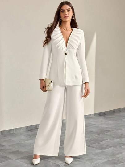 CLARA VERO Vitt plisserat kavajset: Åtsittande plisserad v-ringad kavaj och maxibyxor, perfekt för formella mottagningar eller moderna affärssammankomster, tillverkat av icke-stretchigt dubbelvitt tyg med strukturerade axlar, rynkade detaljer och helt foder