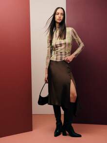 Nöista Cette jupe brune raffinée présente un ourlet asymétrique et des détails de boutons sur le côté. Fabriquée en satin lisse, elle tombe magnifiquement et est idéale pour les tenues de vacances de printemps, les dîners de Thanksgiving ou les tenues d'anniversaire pour femmes. Elle se marie facilement avec des hauts chics pour femmes. - Tabac - Voir 4