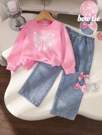 Genkimix Kids 这款女童春秋冬返校新款针织卫衣套装，饰有蝴蝶结图案，圆领长袖设计，搭配粉色蝴蝶结装饰的蓝色牛仔裤，两件套，适合女孩日常穿着，可爱又优雅，适合上学、外出、派对等场合。