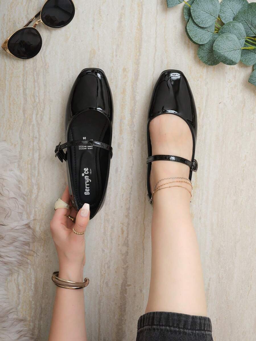 Estas sandalias tipo Mary Jane son ideales para ocasiones casuales, laborales o salidas semi-formales donde se requiere un look pulido pero relajado. Gracias a su diseño sobrio y elegante, son perfectas para combinar con pantalones rectos, vestidos midi o faldas fluidas. Están elaboradas en material sintético tipo recubierto que aporta un acabado brillante y sofisticado, con una suela plana de goma que brinda estabilidad - Negro - Ver 1