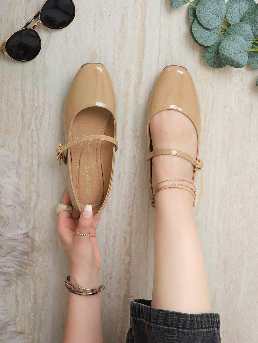 Estas sandalias tipo Mary Jane son ideales para ocasiones casuales, laborales o salidas semi-formales donde se requiere un look pulido pero relajado. Gracias a su diseño sobrio y elegante, son perfectas para combinar con pantalones rectos, vestidos midi o faldas fluidas. Están elaboradas en material sintético tipo recubierto que aporta un acabado brillante y sofisticado, con una suela plana de goma que brinda estabilidad - Beis - Ver 1