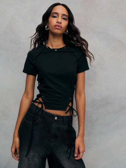 TypaGal Una blusa negra con detalles de ojetes y cordones a los lados y los hombros. Perfecta para añadir un toque audaz a cualquier atuendo, esta blusa negra se combina sin esfuerzo con faldas o vaqueros.