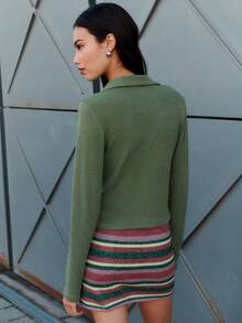 Nöista 这款橄榄绿上衣采用巧妙的扭结前襟设计，凸显腰线，搭配柔软的领子和长袖。采用弹力舒适的针织面料制成，是打造时尚秋季造型、冬季叠穿或休闲假日聚会的理想之选。 - 軍綠色 - 查看 2