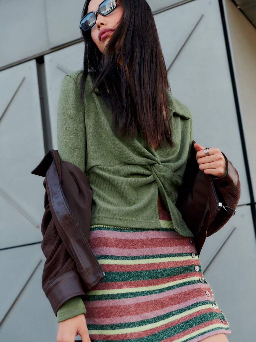 Nöista 这款橄榄绿上衣采用巧妙的扭结前襟设计，凸显腰线，搭配柔软的领子和长袖。采用弹力舒适的针织面料制成，是打造时尚秋季造型、冬季叠穿或休闲假日聚会的理想之选。 - 軍綠色 - 查看 1