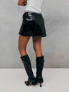 TypaGal Audaz y moderno, esta falda negra está confeccionada en piel sintética brillante con un diseño envolvente asimétrico y una hebilla llamativa. Una falda mini negra perfecta para conjuntos con un toque edgy o para salir de noche. - Negro - Ver 4
