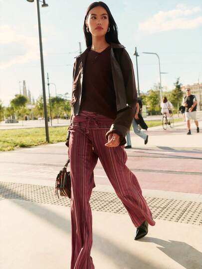 Nöista بنطلون مريح بخطوط بألوان دافئة ذو ساق واسعة وخصر مربوط؛ مريح للاسترخاء خلال فصلي الخريف والشتاء وسهل التنسيق للتجمعات الكاجوال في عيد الهالوين أو عطلات نهاية الأسبوع المريحة.