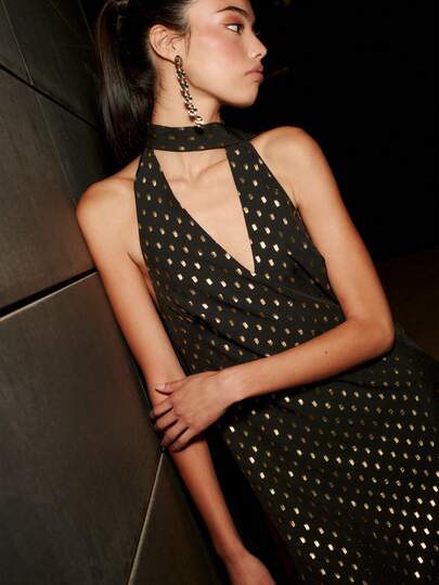 Nöista 这款黑色连衣裙饰有金色细节，采用挂脖领口和修身迷你裙摆设计，是节日夜晚的完美之选。这款闪亮连衣裙专为女性生日装扮、优雅造型或春假派对而设计，为女性的春假时尚装扮增添魅力和自信。