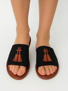 Sandalias planas, abiertas, decoradas, estas sandalias destacan por su diseño minimalista adornado con borlas marrón oscuro al frente que aportan un detalle distintivo y elegante. Son perfectas para ocasiones informales como paseos por la ciudad, reuniones casuales, vacaciones en la playa o salidas de fin de semana, ya que combinan con atuendos relajados y frescos. - Negro - Ver 2