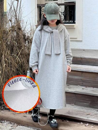 年轻女孩休闲灰色连衣裙，采用柔软舒适的面料制成，搭配针织披肩，打造时尚造型，圆领长袖设计，下摆开衩，宽松休闲版型，适合日常外出和公园活动，中等厚度，春秋季